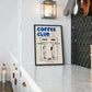 Framed poster titled 'Coffee Club' on a wall in a modern interior setting.