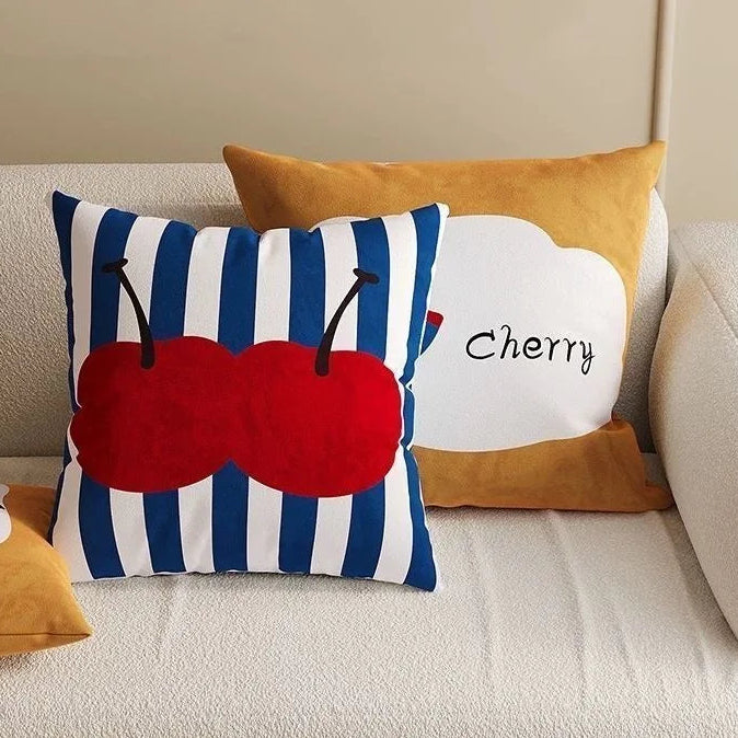 Decorative pillows with cherry design on a sofa