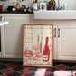 Decorative kitchen towel with red and white design on a kitchen counter.