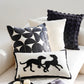 Decorative pillows with geometric patterns and a silhouette design on a sofa.