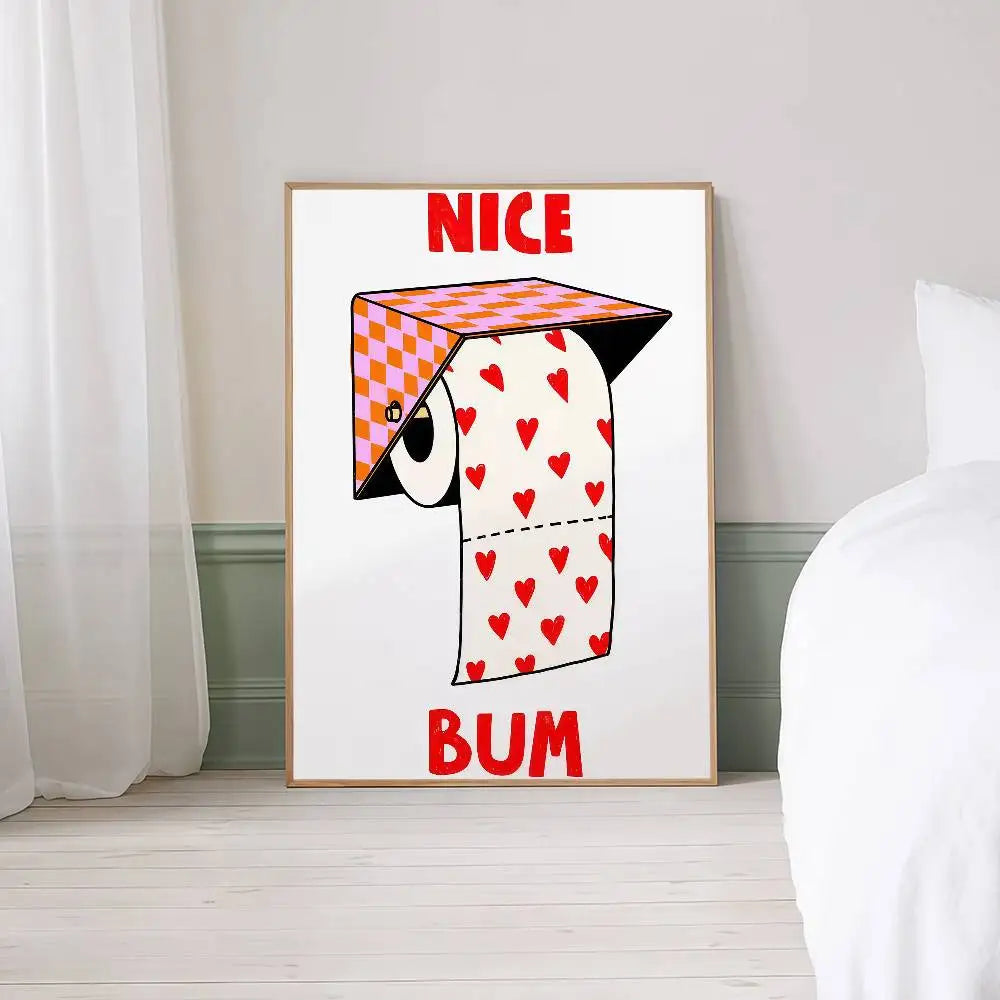 Framed artwork with a cartoon character and text 'NICE BUM' on a white wall.