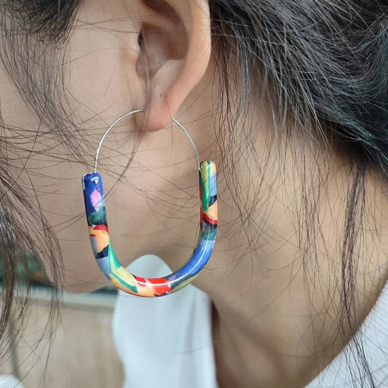 Close-up of a colorful hoop earring worn by a person.