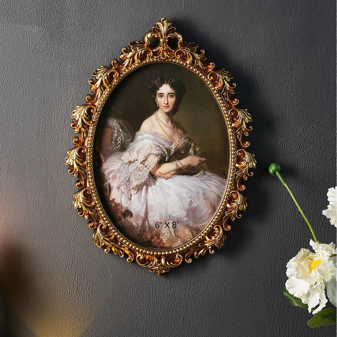 Portrait of a woman in an ornate gold frame on a dark wall with flowers.