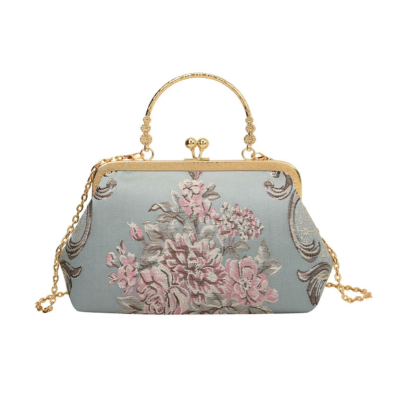 Floral embroidered handbag with gold chain and handle on a white background