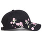 Black cap with pink floral embroidery on a white background