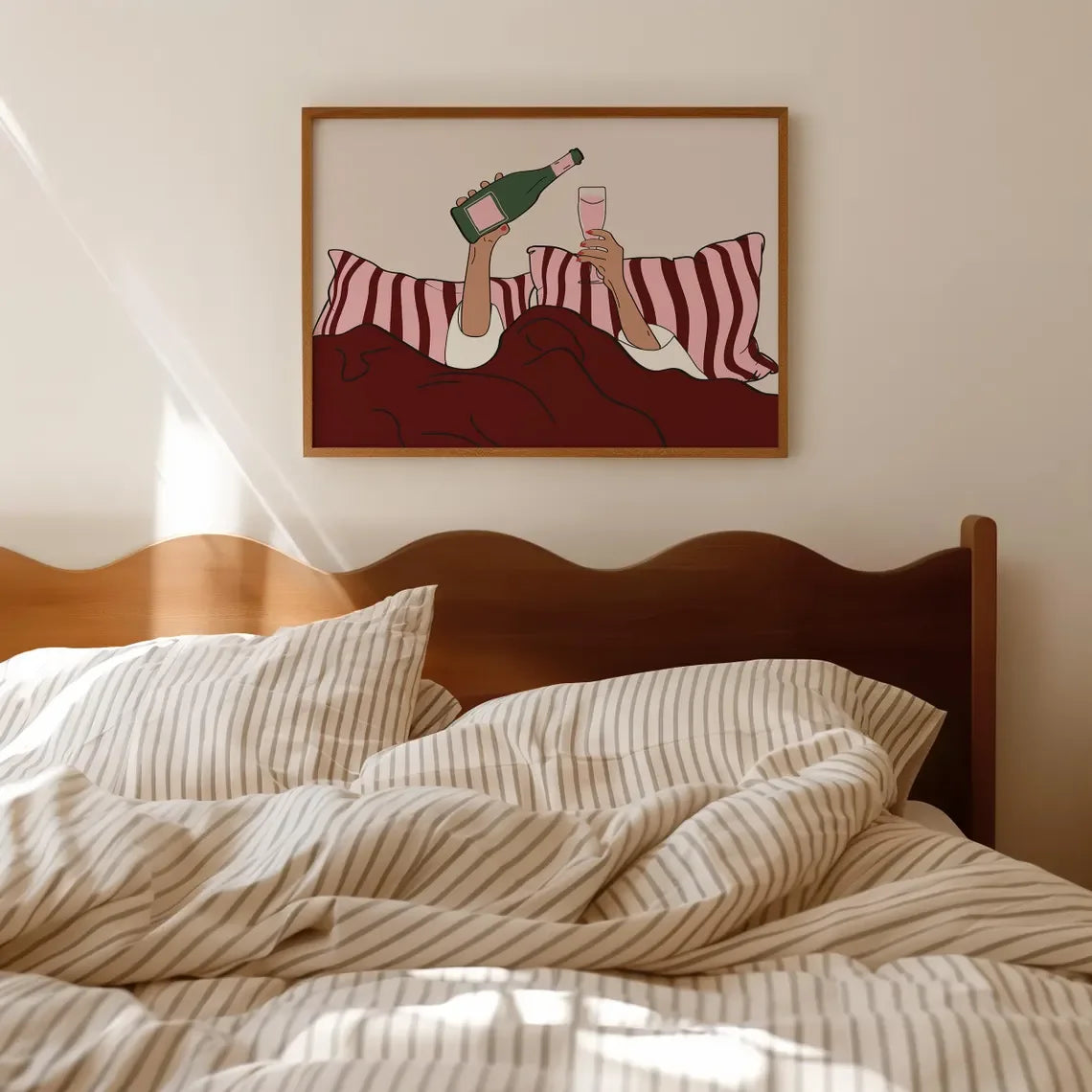 Framed artwork above a bed with striped bedding and wooden headboard.
