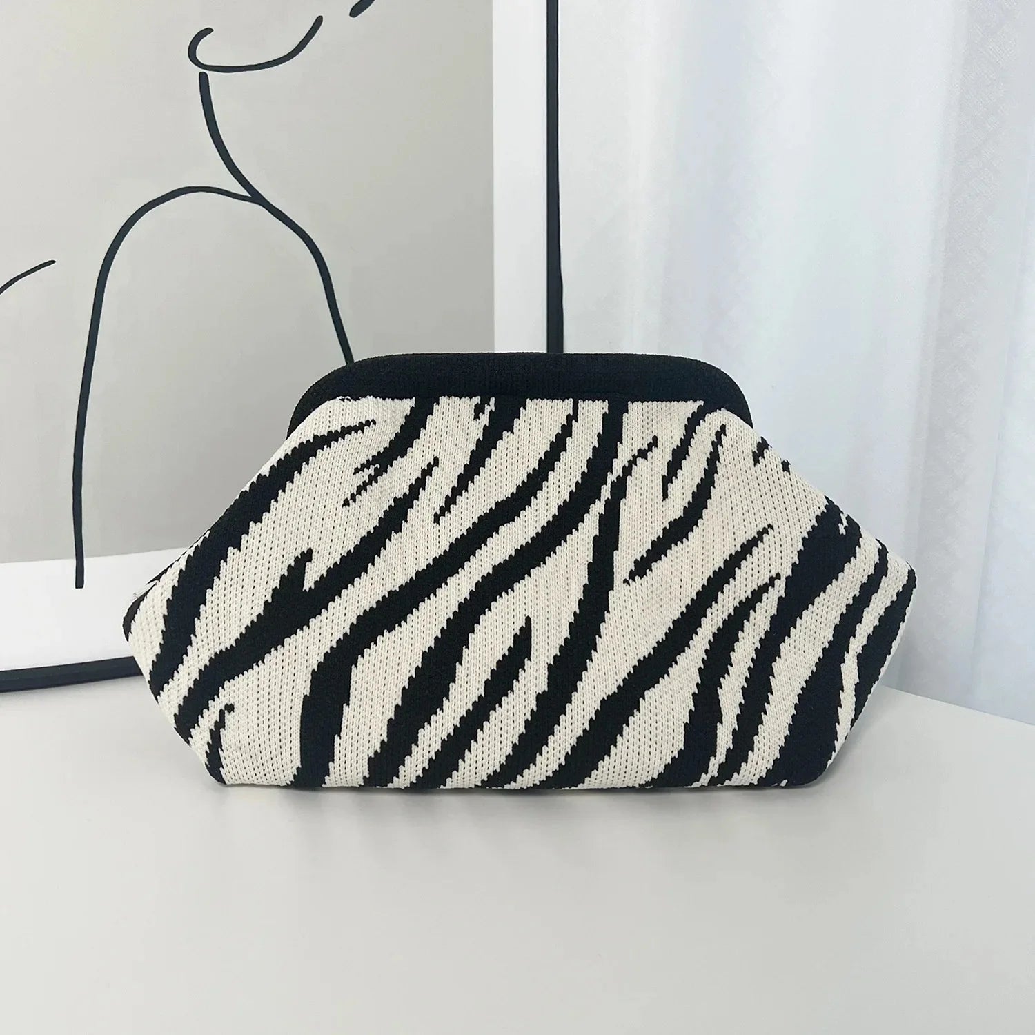 Zebra patterned pouch on a white surface with a minimalistic background