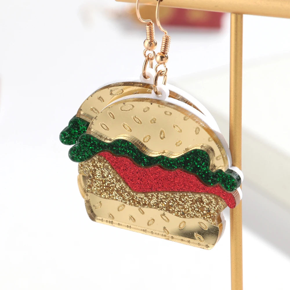 Hamburger-shaped earrings on a stand with a white background