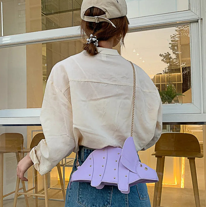 Person wearing a light-colored jacket with a purple waist bag in an indoor setting.