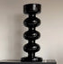 Black decorative vase with spiral design on a neutral background