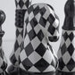 Black and white checkered chess pieces on a light background