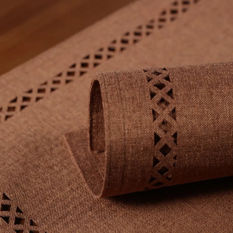 Brown textured roll of paper with geometric cut-out design on a matching surface.