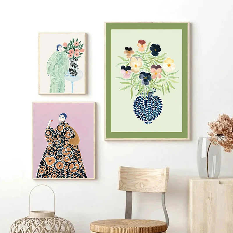 Three framed artworks on a wall with a chair and decorative items below.