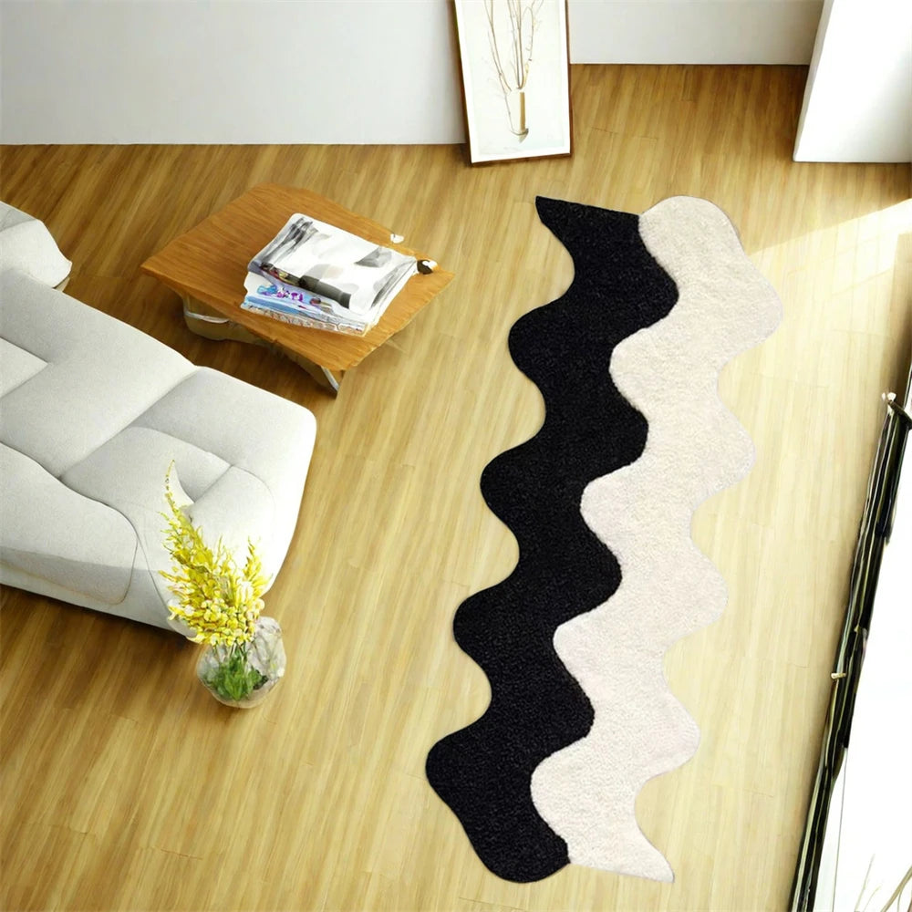 Black and white wavy rug on a wooden floor with a sofa and coffee table in the background.