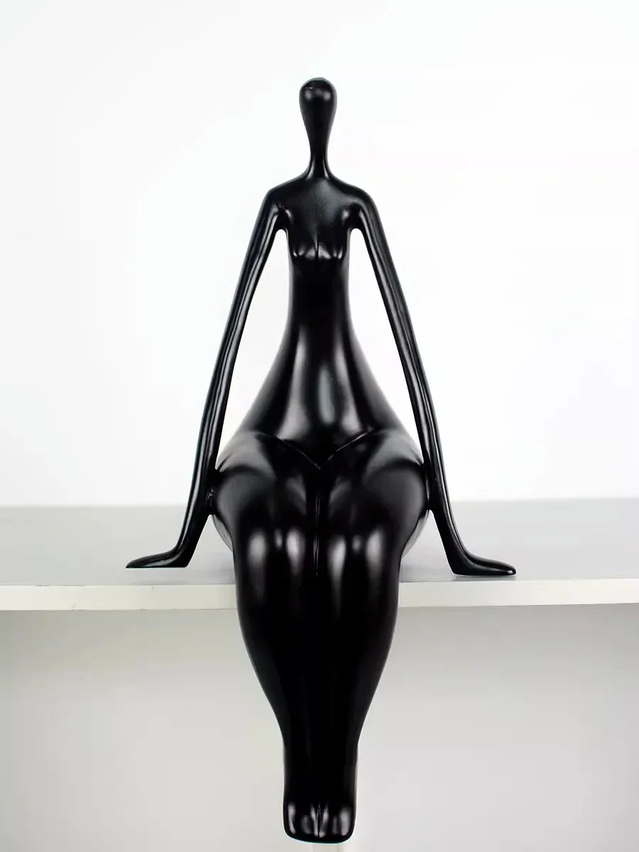 Black mannequin on a white shelf against a white background