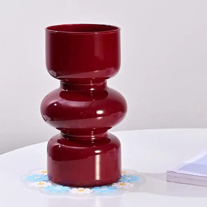 Red vase on a white surface with a white background