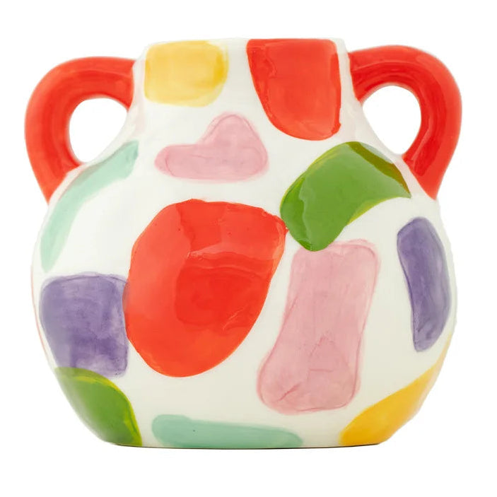 Colorful ceramic pitcher with abstract patterns on a white background