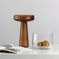 Wooden bowl and glass container on a white surface with a gray background