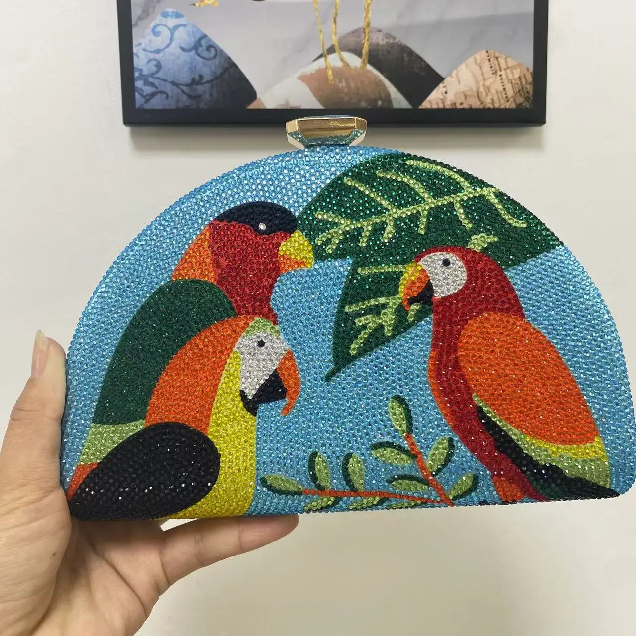 Handheld clutch bag with parrot design on a plain background