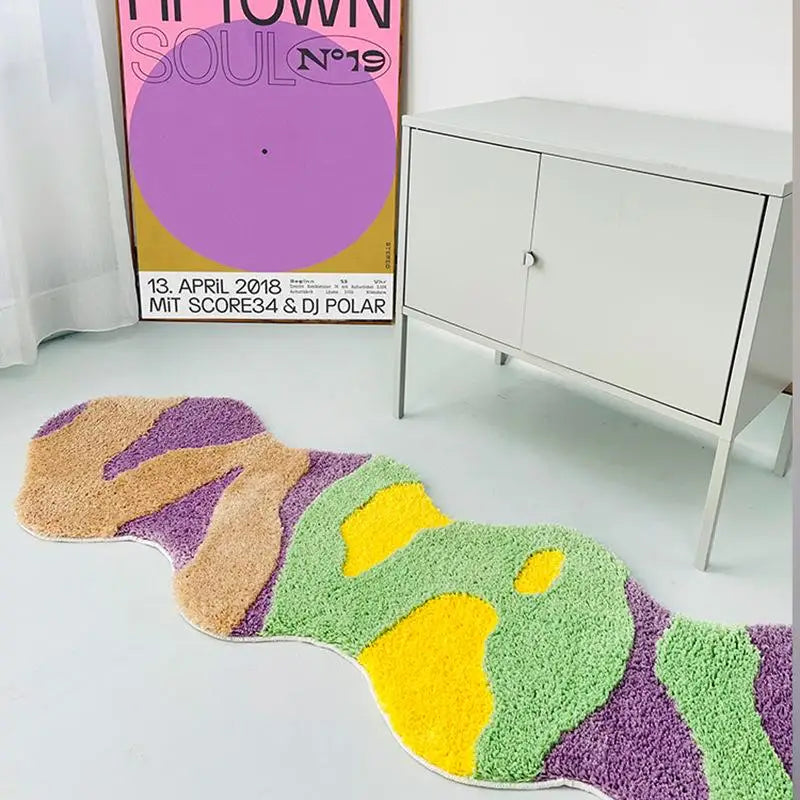 Colorful abstract rug on a light gray floor with a poster in the background.