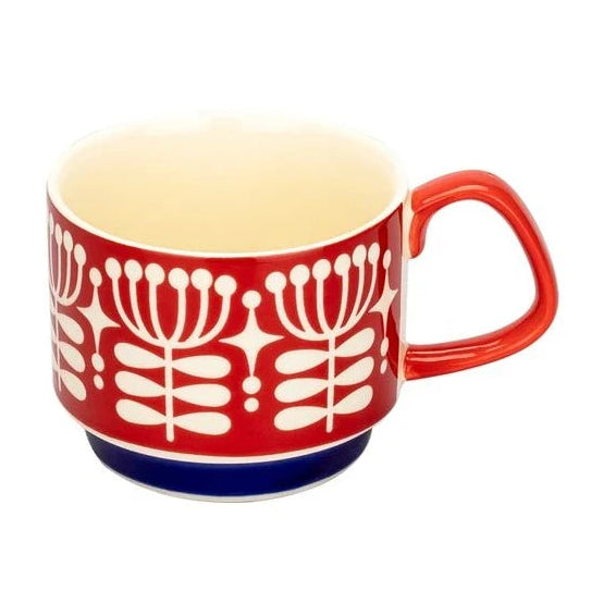 Red mug with white floral pattern on a white background