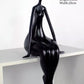 Black abstract sculpture on a white surface with dimensions displayed.