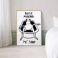 Framed artwork with a black and white illustration of a person in a bathtub and text 'BUSY MAKING ME SOUP' on a white wall.
