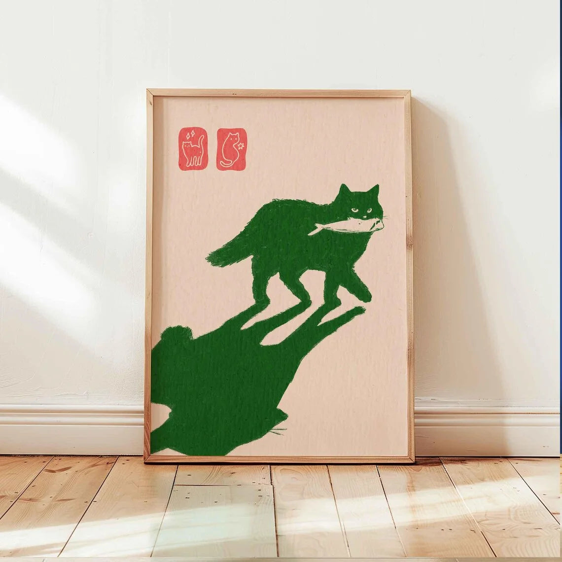 Framed artwork of a green cat and shadow on a beige background