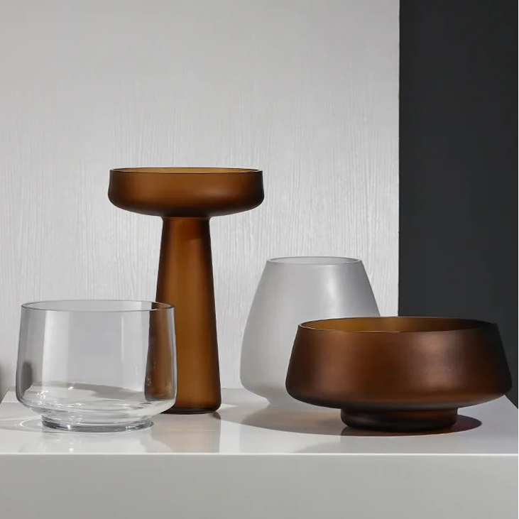 Set of three decorative vases on a white surface with a neutral background