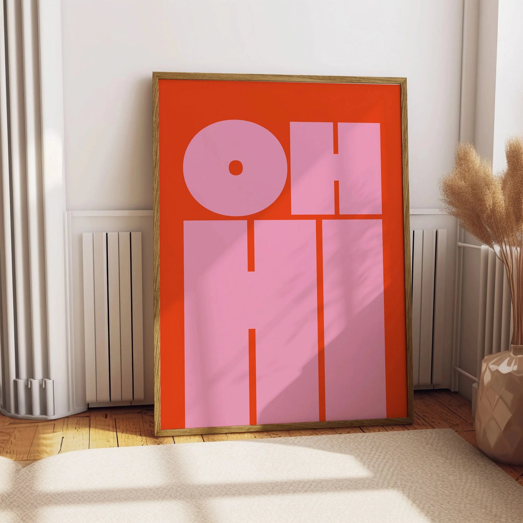 Framed artwork with 'OH HI' text on a red background in a room setting.