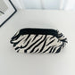 Black and white zebra-striped blanket on a white surface