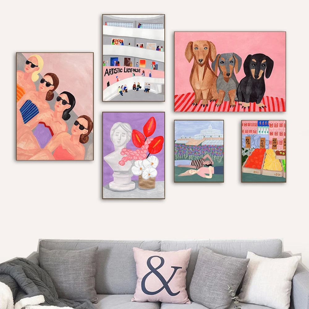 Collection of colorful paintings on a wall above a gray sofa with decorative pillows.