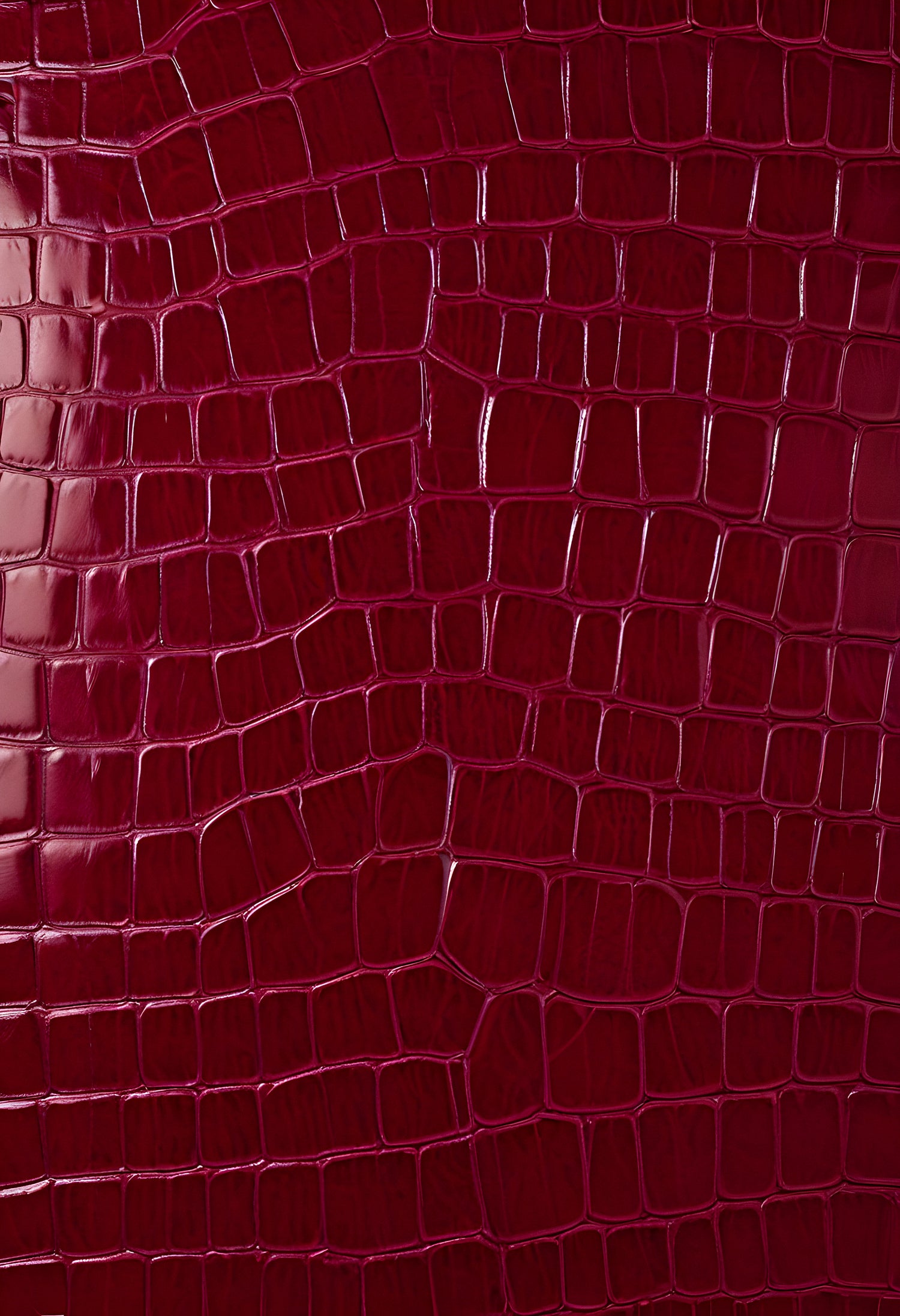 Rich burgundy crocodile leather texture with intricate patterns showcasing luxury and craftsmanship