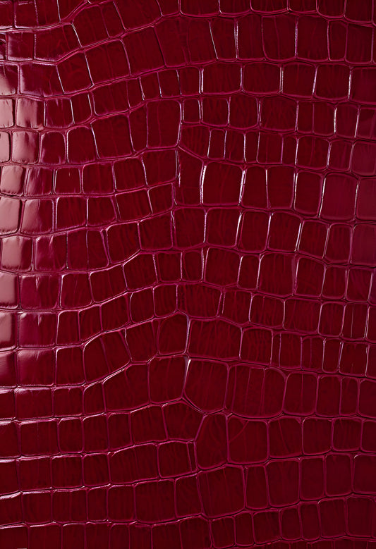 Rich burgundy crocodile leather texture with intricate patterns showcasing luxury and craftsmanship