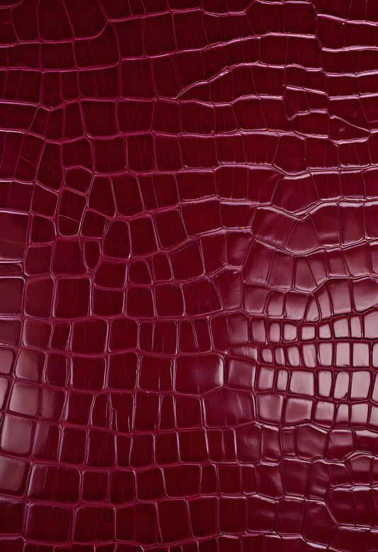 Rich burgundy crocodile leather texture with intricate patterns showcasing luxury and craftsmanship