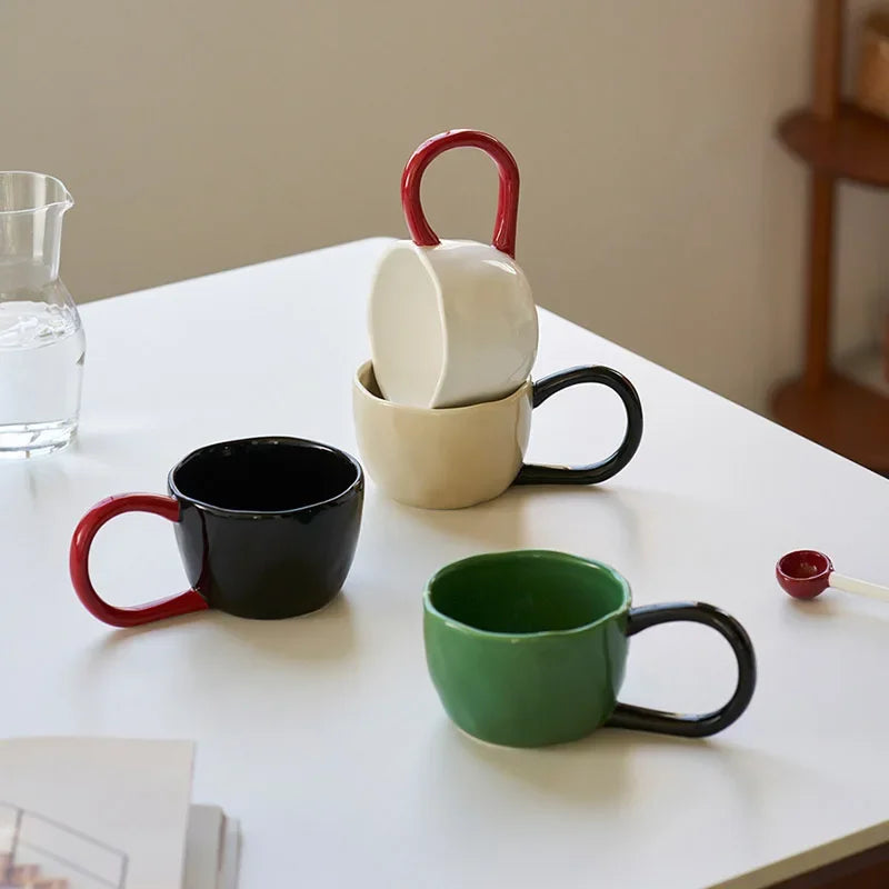 Set of colorful mugs on a white surface with a neutral background