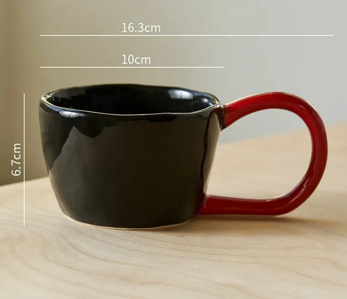 Black mug with red handle on a wooden surface, showing measurements and weight capacity.