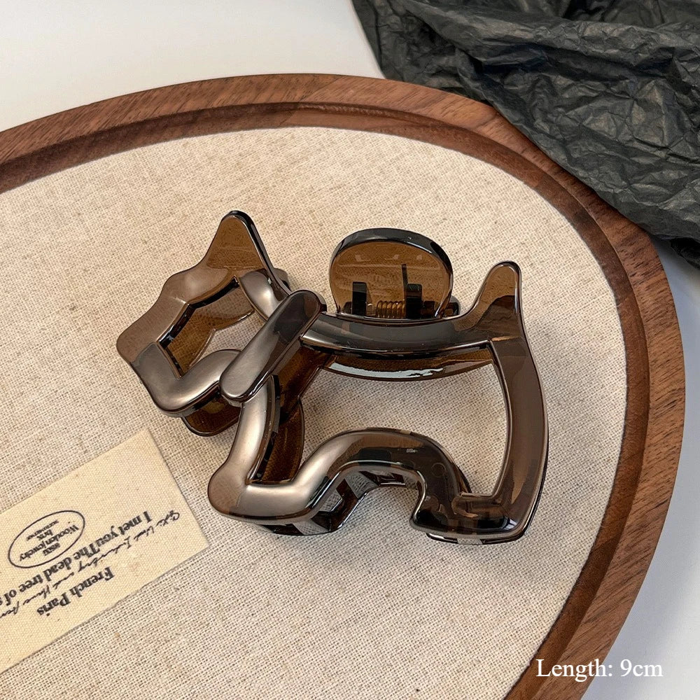 Metallic dog-shaped object on a wooden tray with a beige surface