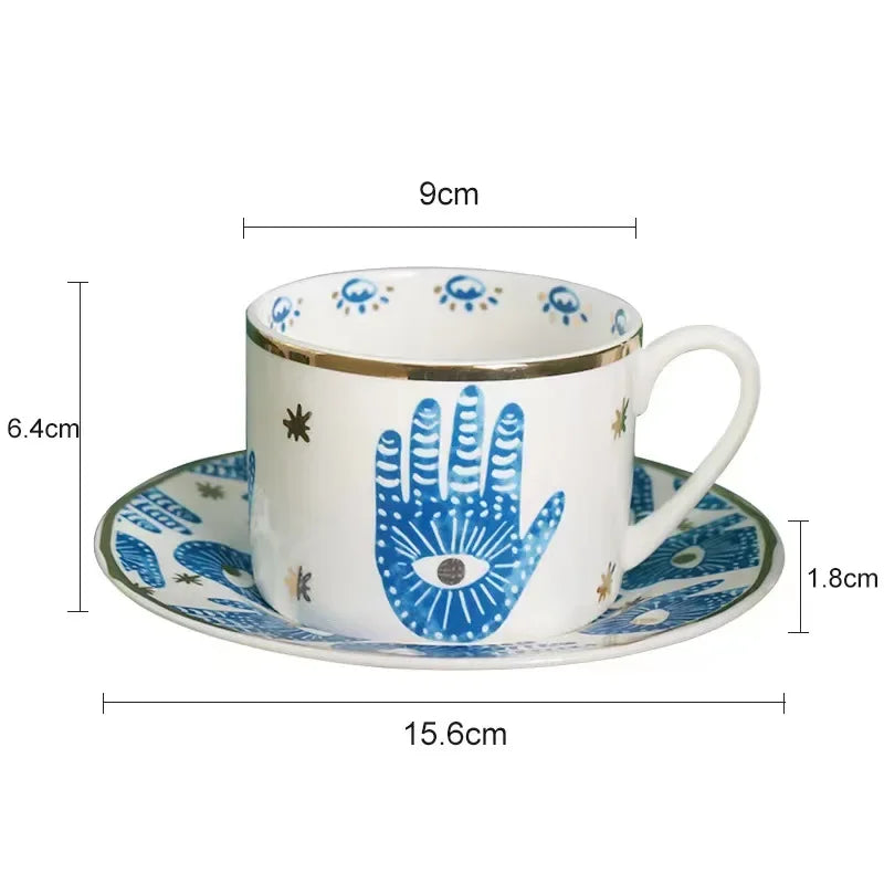 Ceramic cup and saucer with blue hand design and measurements on a white background