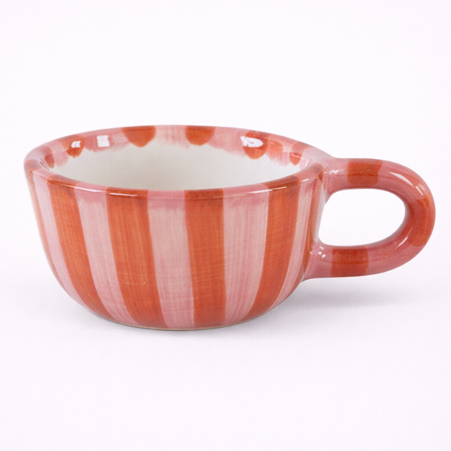 Ceramic cup with red and white striped pattern on a white background