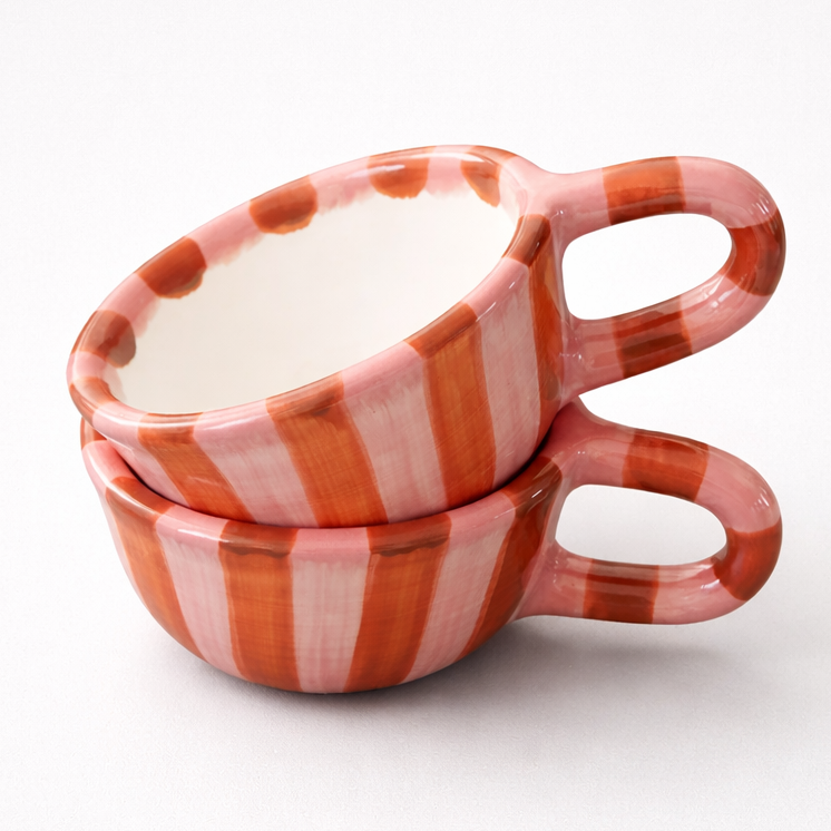 Two stacked ceramic cups with red and white striped pattern on a white background