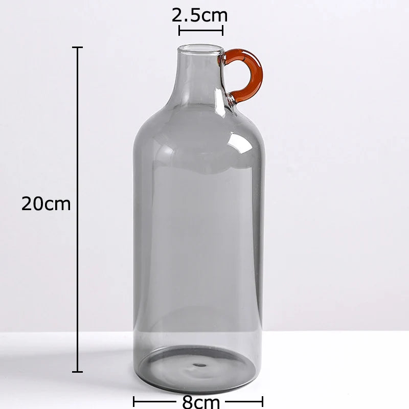 Clear glass bottle with a red handle, shown with measurements on a white background