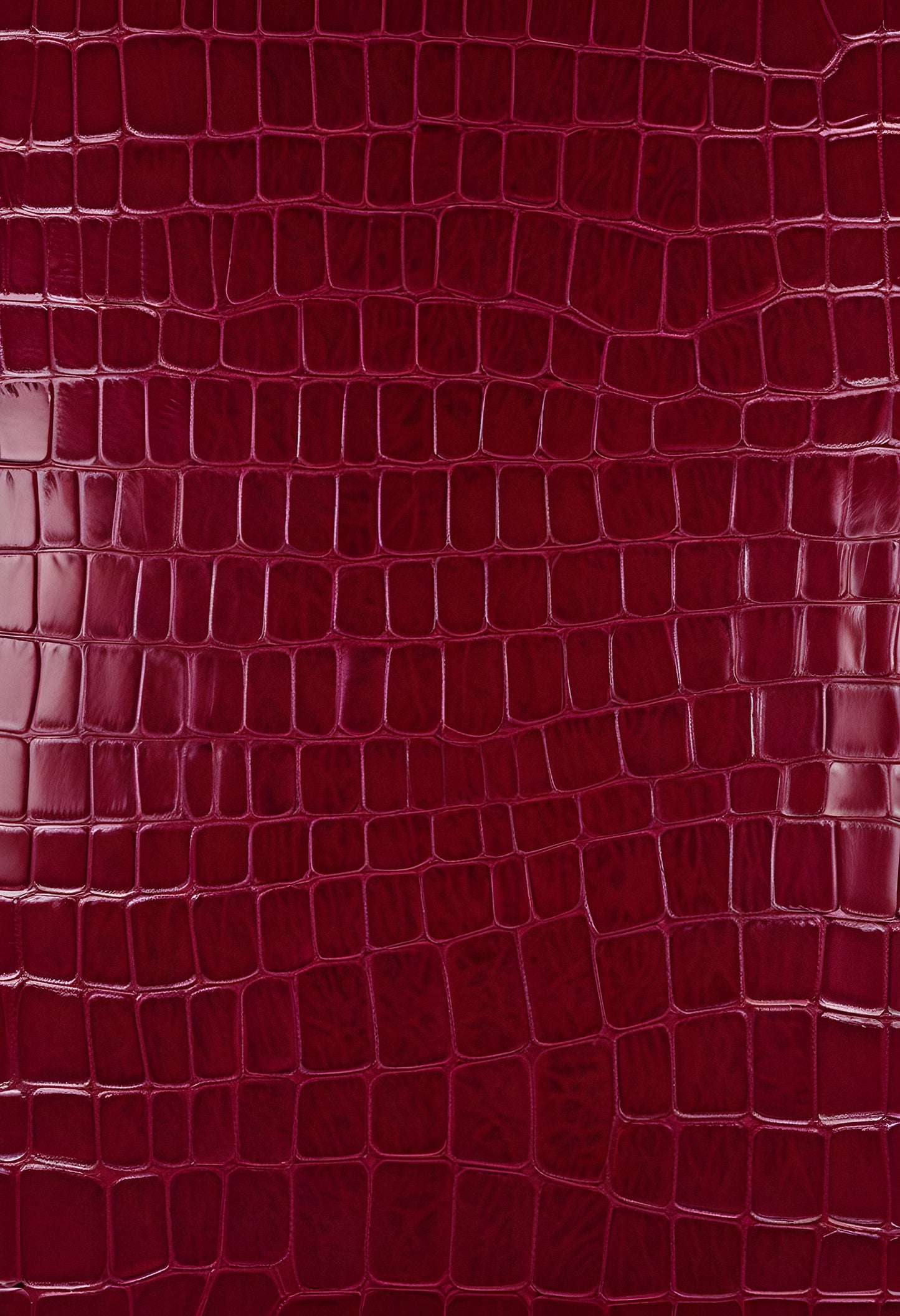 Rich burgundy crocodile leather texture with intricate patterns showcasing luxury and craftsmanship