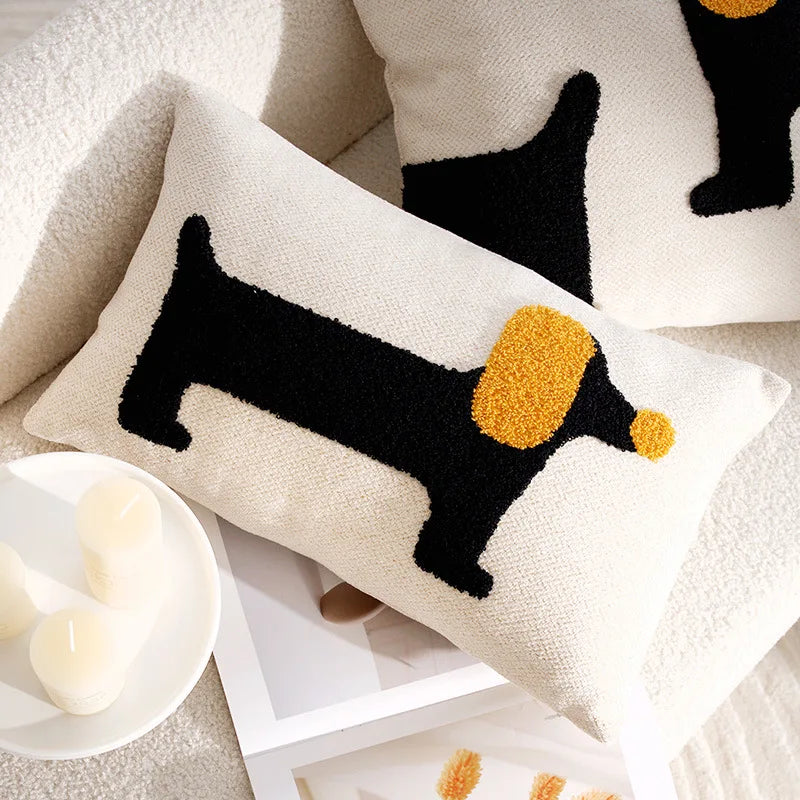 Decorative pillow with a dachshund design on a soft surface.