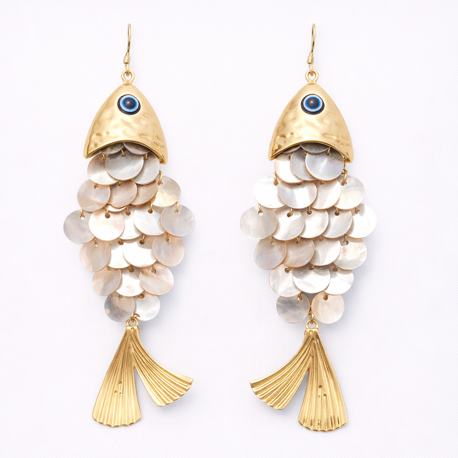 Gold and white fish-shaped earrings on a light gray background