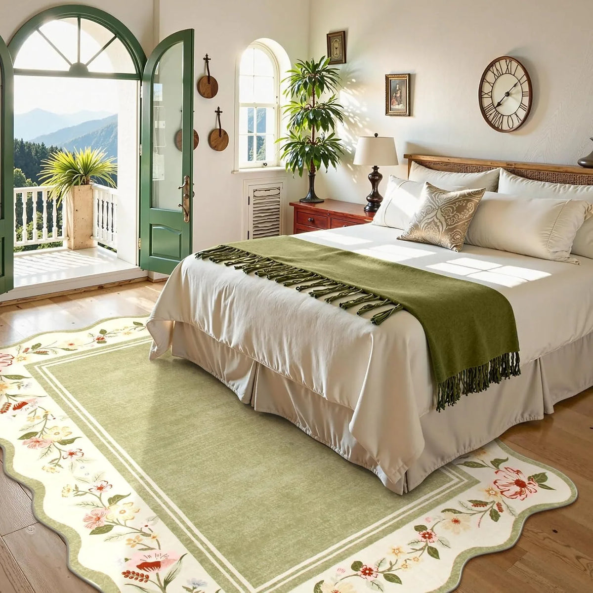 Neatly made bed with green throw blanket in a bedroom with floral rug and mountain view.