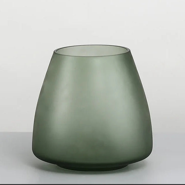 Green glass vase on a light gray background