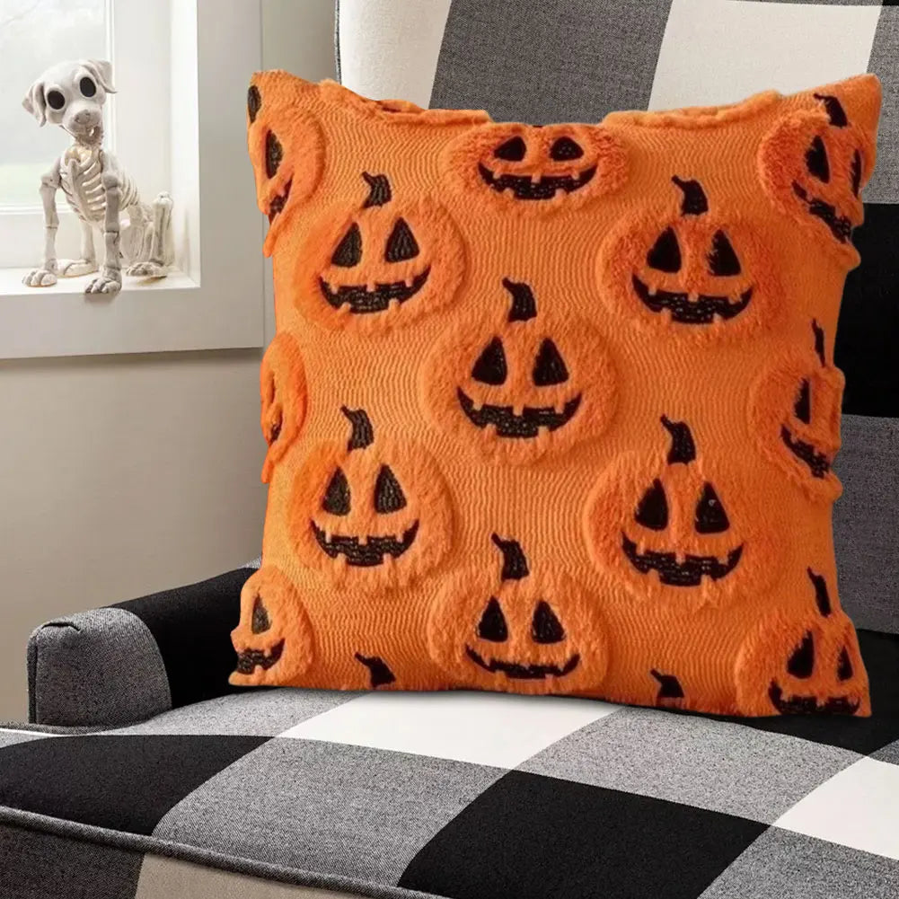 Orange pillow with black jack-o'-lantern faces on a checkered couch