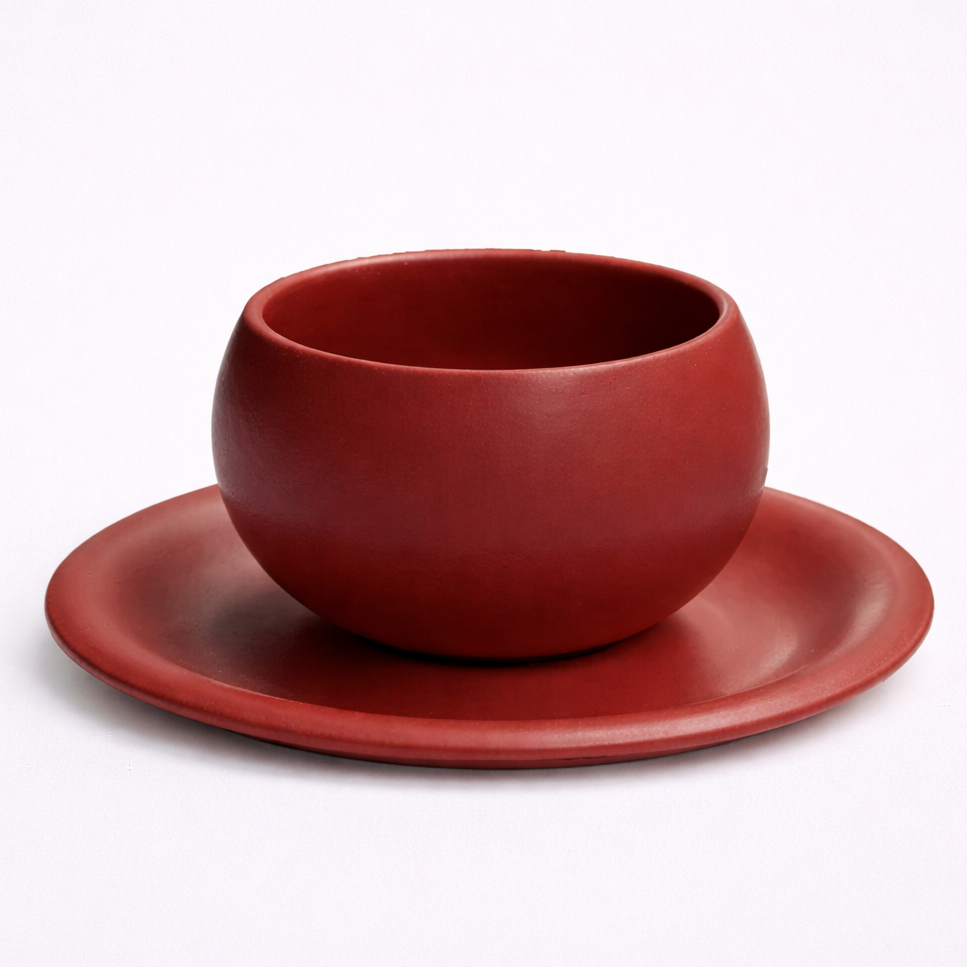 Red ceramic cup and saucer on a white background