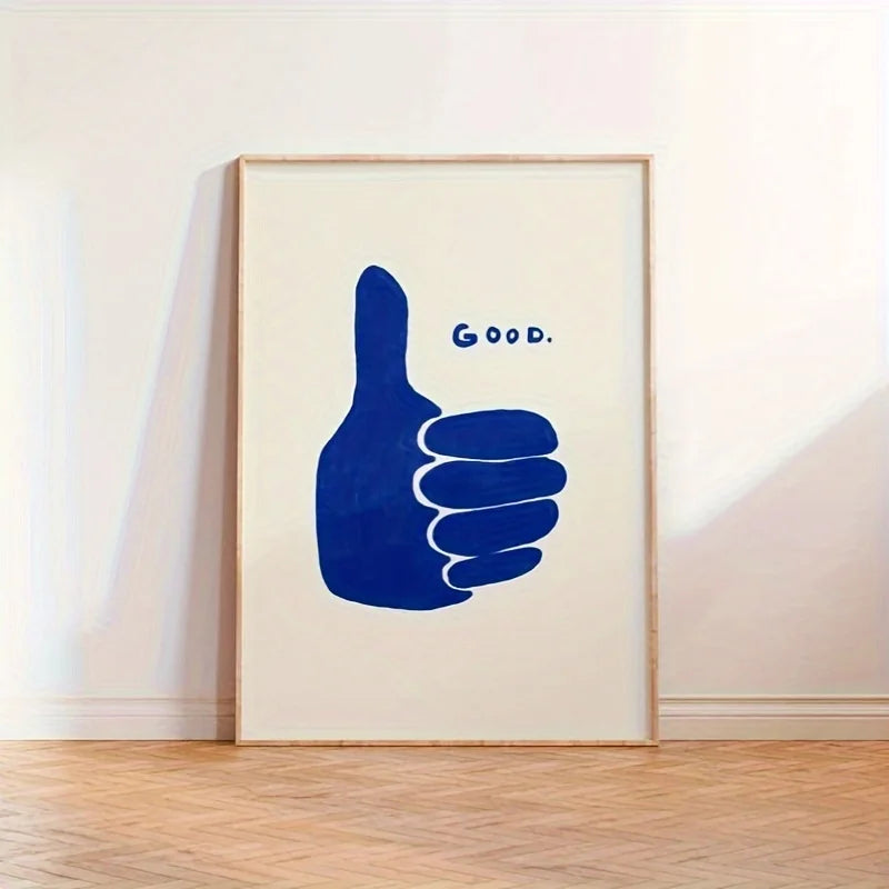 Framed artwork with a blue hand giving a thumbs up and the word 'GOOD.' on a white wall.